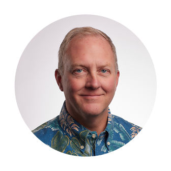 Smiling headshot of Dan Nega, Chief Customer Success Officer at Nakupuna Companies, with short blond hair and a blue floral aloha shirt.