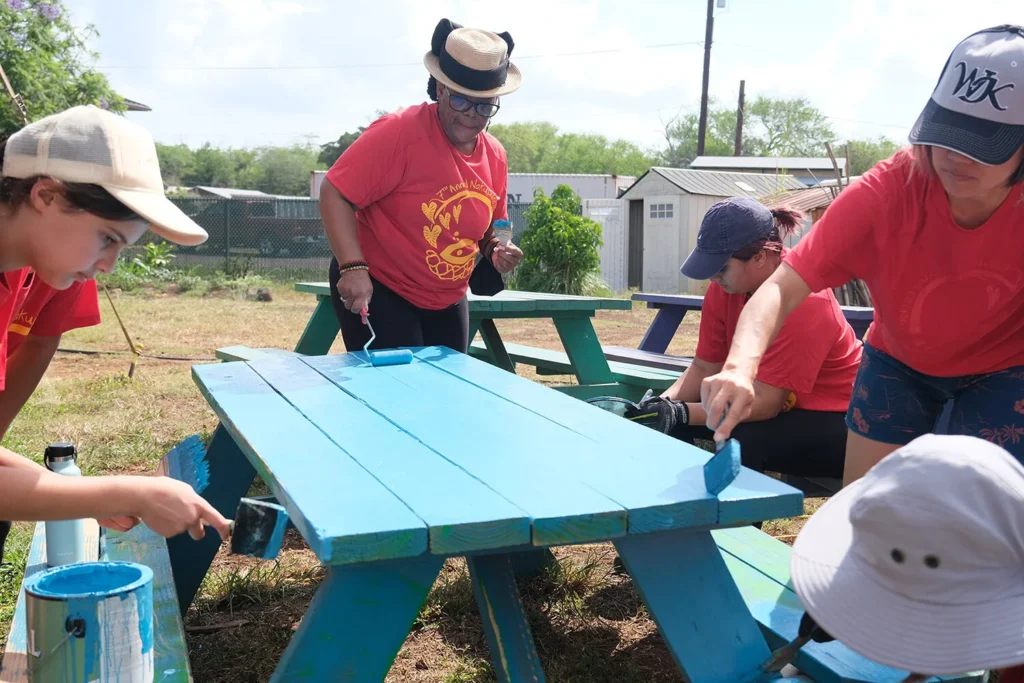 Malama Loko Ea Foundation Nakupuna Companies Most Charitable Companies 2 Nakupuna employees volunteer, painting picnic tables bright blue as part of their community service initiative, showcasing Nakupuna Companies giving back to communities and supporting local organizations in Hawaii. This image is featured on the Nakupuna Companies website.
